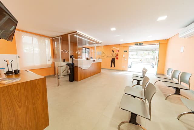 Uma sala de espera com cadeiras e uma sala de atendimento